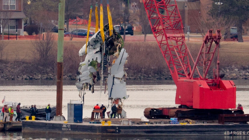 A large portion of the damaged plane fuselage is lifted from the Potomac River during recovery efforts