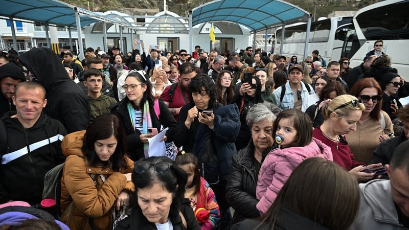 People wait for a ferry in the port of Athinios