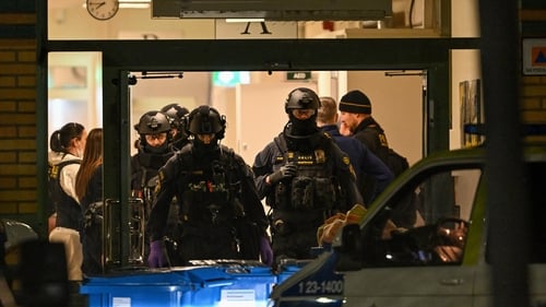 Police officers pictured working at the scene of the shooting at Risbergska School in Örebro