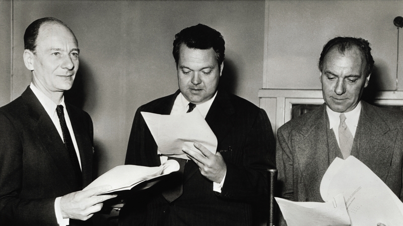 Sir John Gielgud, ar chlé, mar Sherlock Holmes, Sir Ralph Richardson, mar Dr. Watson agus Orson Welles, eatartha, mar 'arch-villain' Professor Moriarty, i mbun léirithe raidió de chuid an BBC.