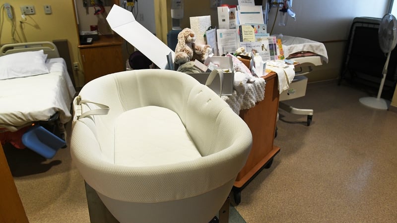 Cuddle Cot a choimeádan an leanbh compórdach.