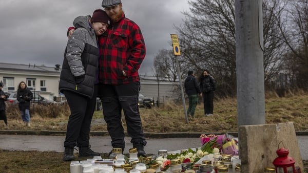 Teddies, candles and flowers are seen at a makeshift memorial for the victims of the gun attack
