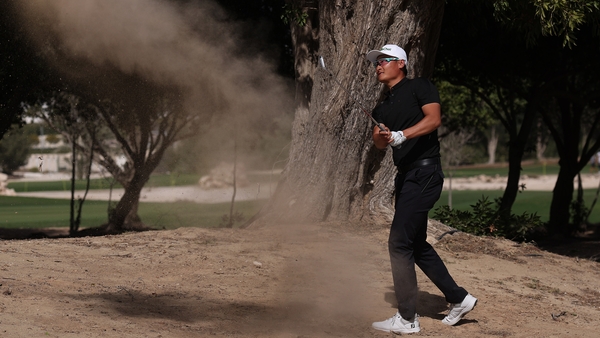 Haotong Li of China plays his second shot on the ninth hole at Doha Golf Club