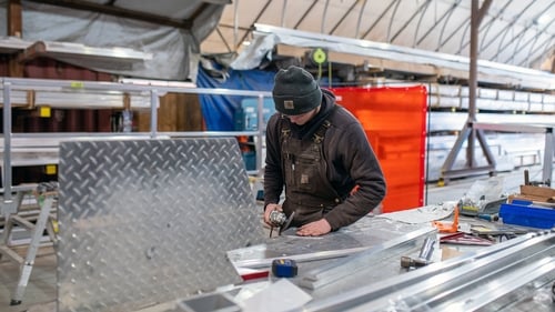 A worker preps aluminium parts for welding at a facility in British Columbia, Canada