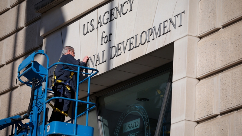 A worker removes the USAID sign on their headquarters in Washington last week