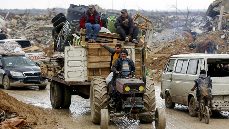 Displaced Palestinians return to their lands in the north from the south as they pass through the al-Rashid Street during harsh weather conditions in Gaza City