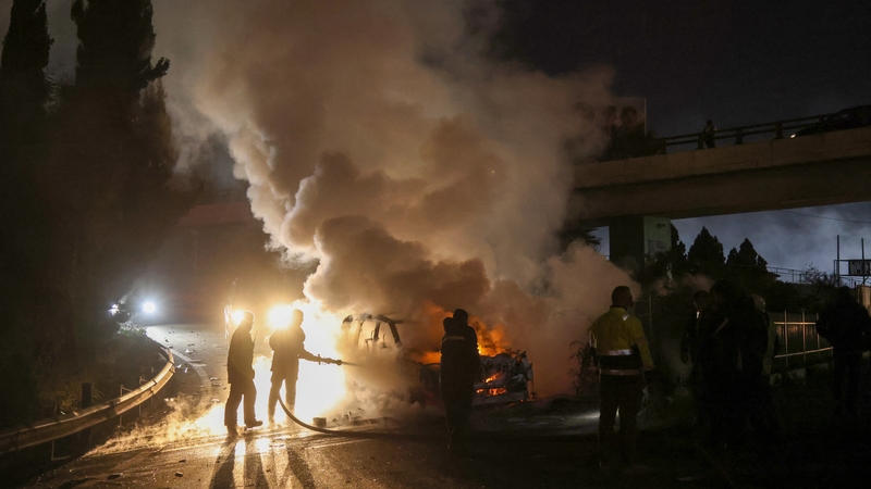 Firefighters extinguish a burning UNIFIL vehicle on the road leading to Beirut's international airport in Lebanon