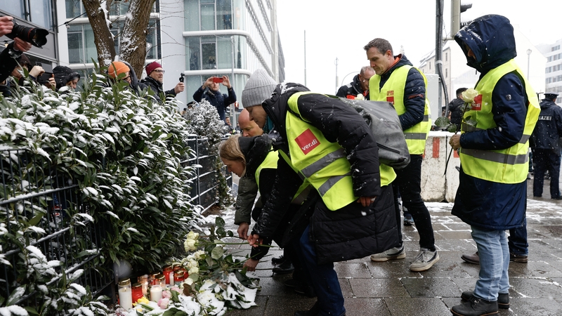 Members of German union Verdi pay their respects at the scene where a car drove into a crowd in the southern German city