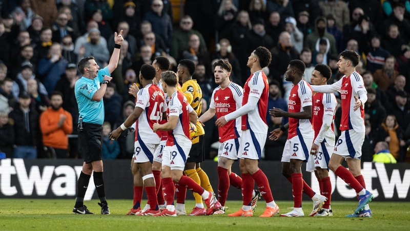 Referee Michael Oliver is surrounded by Arsenal players after sending off Myles Lewis-Skelly against Wolves