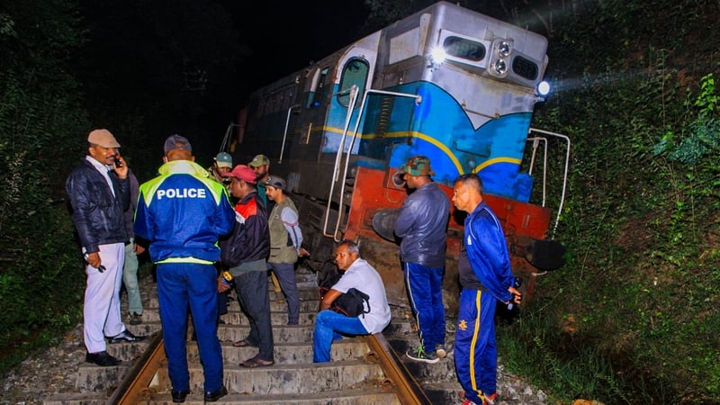 Police and railway personnel examine the derailed train at Habarana in eastern Sri Lanka