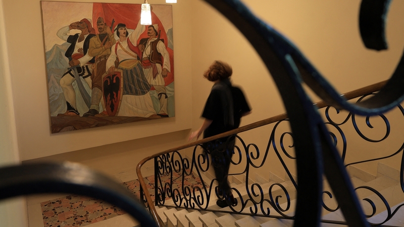 An artists walks down the stairs at the villa of former Albanian dictator Enver Hoxha