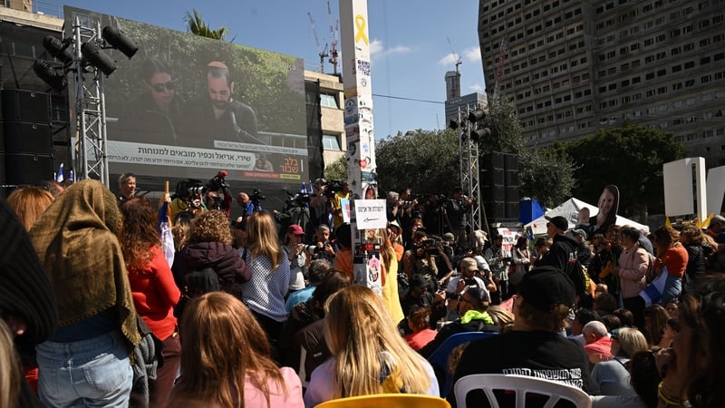 A crowd watches a live feed of Yarden Bibas as he speaks at the funeral of his wife and children on a screen in what is known as Hostages Square in Tel Aviv