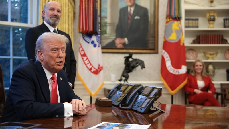 Donald Trump speaks as Commerce Secretary Howard Lutnick looks on after signing executive orders in the Oval Office
