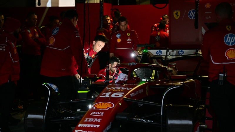 Ferrari mechanics use flashlights during a power outage on the first day of the Formula One pre-season testing