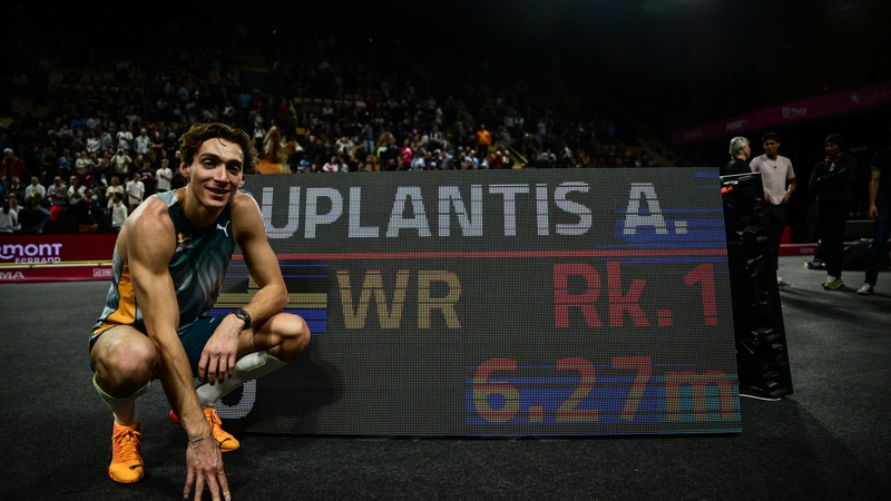 Armand Duplantis poses next to a screen displaying his world record
