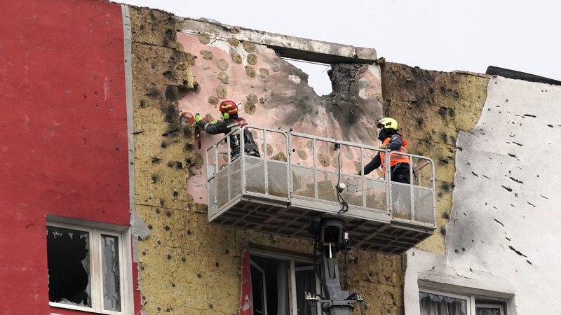 Crews work on the facade of a damaged apartment building in Moscow