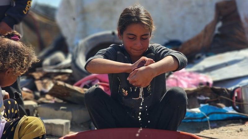 Children support their families by washing clothes at a camp in Khan Younis