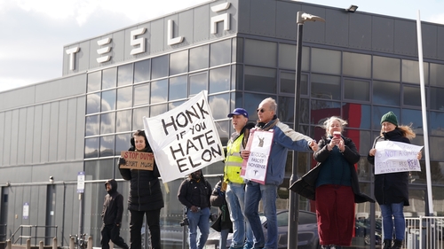 People take part in a protest outside of the Tesla centre at Park Royal in west London