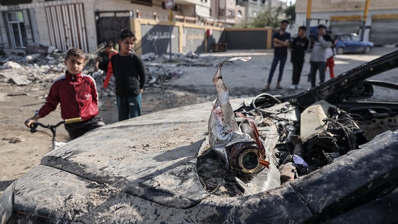 Palestinians look at the car damaged during an Israeli airstrike in Beit Lahiya, Gaza