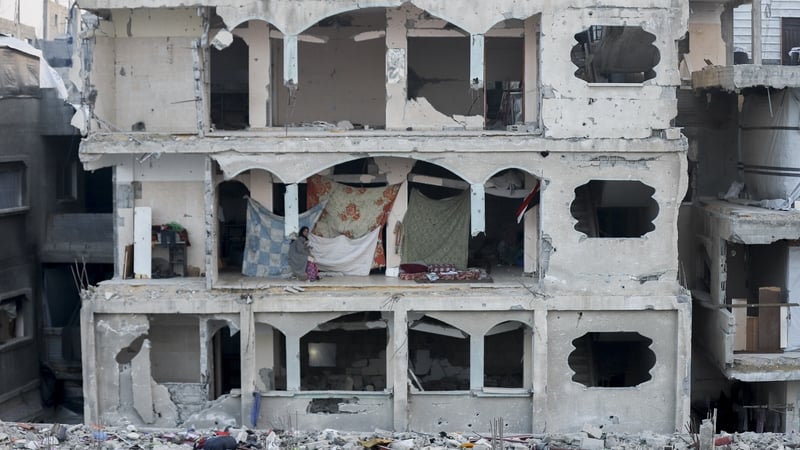 A displaced woman sits in the ruins of a destroyed building in Beit Lahia, Northern Gaza