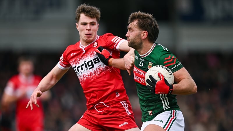 Aidan O'Shea of Mayo (R) holds off Derry's Eoin McEvoy