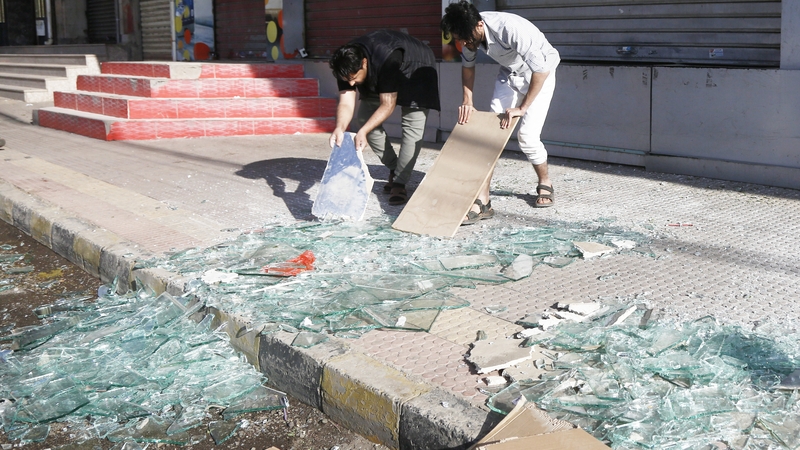 Yemeni people sweep shattered glass from streets after US airstrikes on Sanaa and other provinces