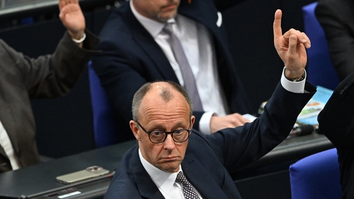 Friedrich Merz, leader of Germany's CDU party, raises his hand during a vote at a session of the Bundestag