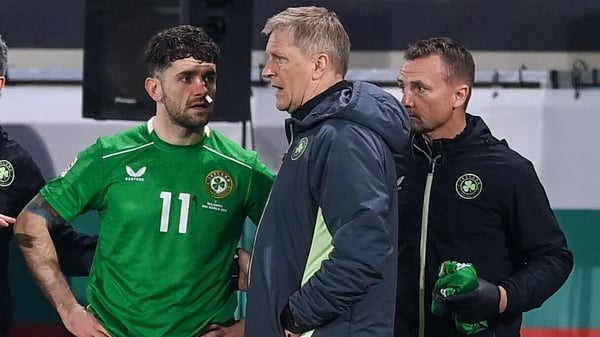 Heimir Hallgrimsson checks on Robbie Brady following his facial injury during the game in Bulgaria