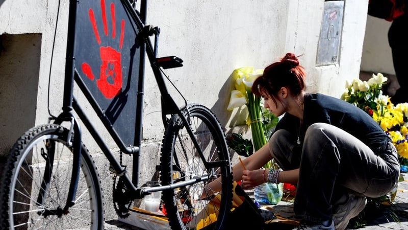 A woman at a memorial in remembrance of a boy who died after suffering severe injuries in the Novi Sad train station tragedy