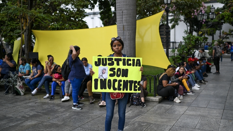 A woman holds a sign reading 'justice they are innocents' during a demonstration in support of Venezuelan migrants sent by the US to a prison in El Salvador