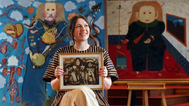 Charlotte Riordan, Head of Contemporary Art at Lyon & Turnbull, holding the painting of The Beatles by the late John Byrne Photos: Press Association