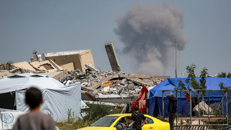 A boy looks on as a cloud of smoke erupts from Israeli bombardment in Beit Lahia in Gaza