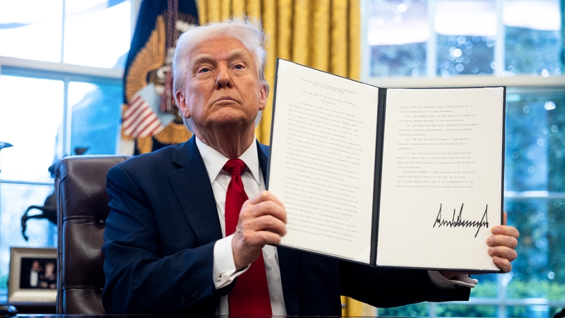 US President Donald Trump displays a signed executive order in the Oval Office of the White House imposing tariffs on cars not made in the US
