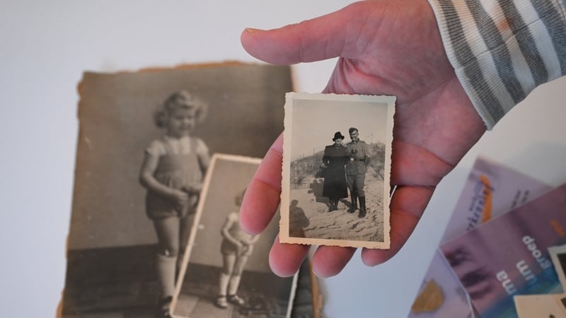 Michael Schuling holds photos of his father as a young boy - the son of a German Nazi soldier and a Dutch woman