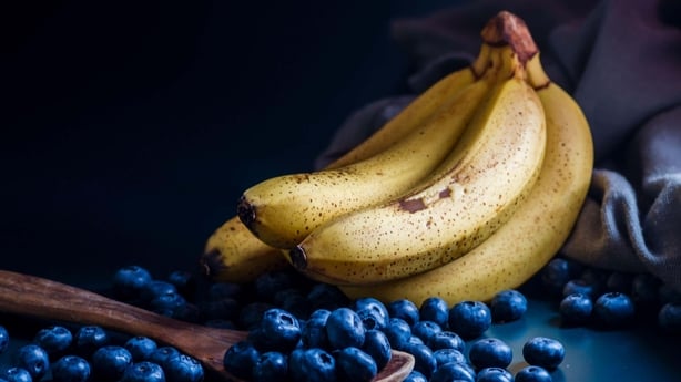 Bananas and Fresh Blueberries blueberry Bowl Table Freshly picked glass bowl. Juicy fresh Bilberry dark food Background. antioxidant. Concept healthy eatin