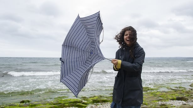 Happy woman laughing and enjoying under sudden rain in a sunny day