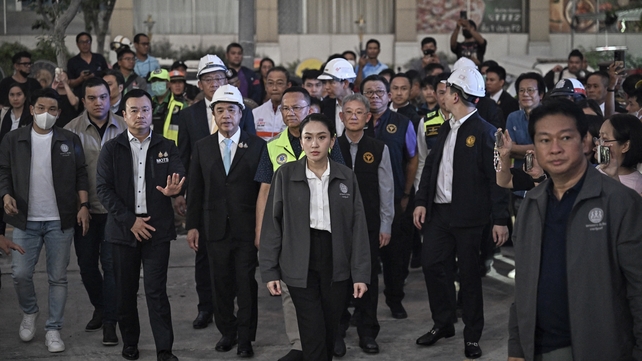 Thailand's Prime Minister Paetongtarn Shinawatra (C) arrives at a construction site where a building collapsed