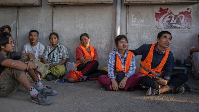 Workers wait for news near the site of a collapsed building, which was under construction in Bangkok, Thailand