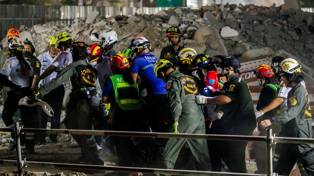 Emergency workers carry a trapped construction worker on a stretcher in Thailand