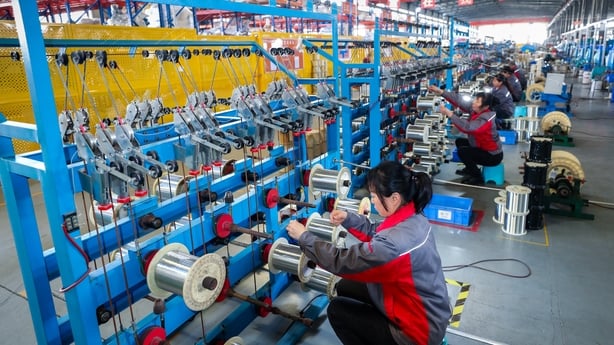 Men and women working with cables in a factory in China