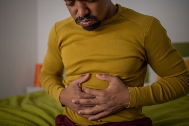 Cropped photo of woman who is experiencing indigestion holding her stomach