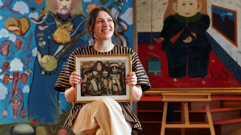 Charlotte Riordan head of contemporary art at Lyon & Turnbull, holding a painting by the late John Byrne of The Beatles. Photo credit: Stewart Attwood/Lyon & Turnbull/PA Wire