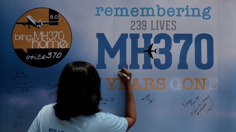A family member writes on a message board during remembrance event in Kuala Lumpur