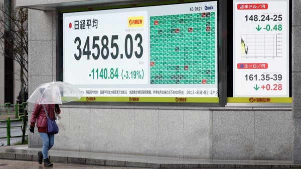 An electronic stock board displays the Nikkei 225 Stock Average and exchange rates in Tokyo, Japan