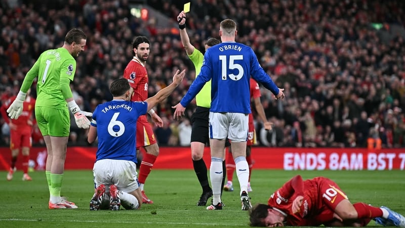 Referee Sam Barrott shows James Tarkowski a yellow card