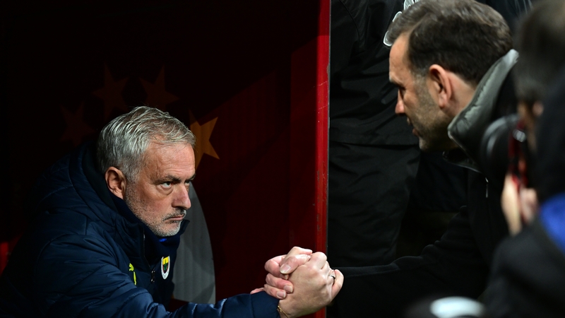Jose Mourinho (L) shakes hands with Okan Buruk before the game