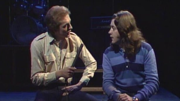 Rory Gallagher, a long haired white man in a blue shirt, being interviewed by Dave Heffernan