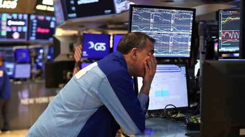 A trader works on the floor of the New York Stock Exchange after markets fall following the new US tariffs