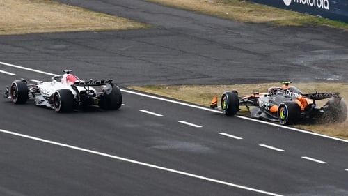 Lando Norris (R) ended up on the grass as he and Max Verstappen exited the pit lane at Suzuka