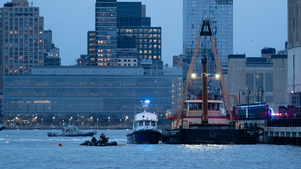 Emergency crews pull wreckage of the helicopter out from the Hudson River